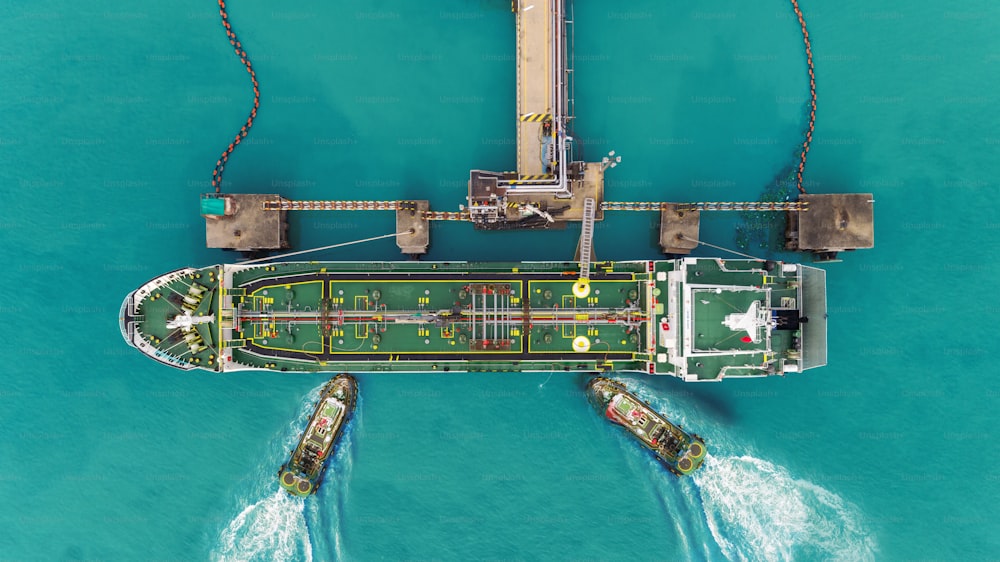 I rimorchiatori trascinano il parco petrolifero della nave petrolifera in porto per il trasferimento del petrolio greggio alla raffineria di petrolio.