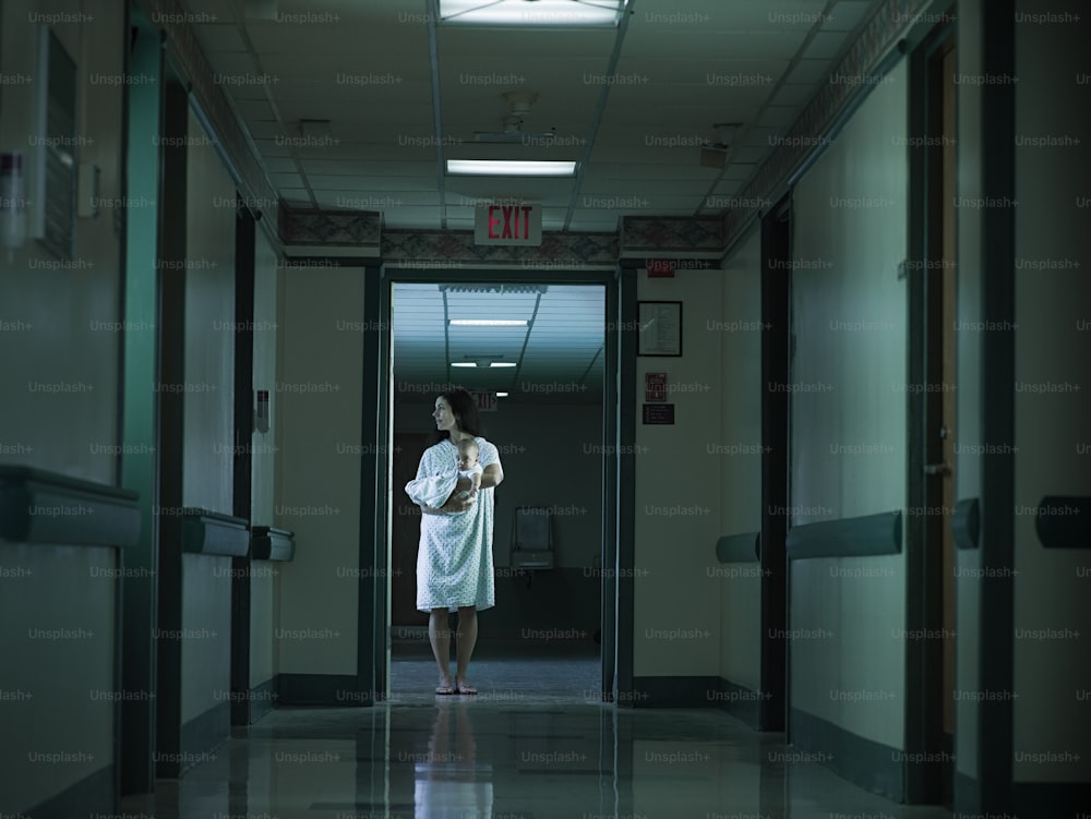 uma mulher com um manto branco em pé em um corredor