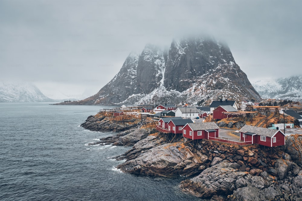 Famous tourist attraction Hamnoy fishing village on Lofoten Islands, Norway with red rorbu houses. With falling snow in winter