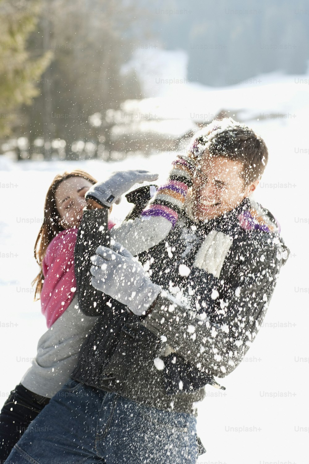 a man and a woman playing in the snow