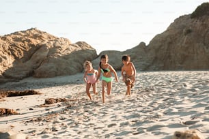 Un groupe de jeunes enfants courant sur une plage de sable