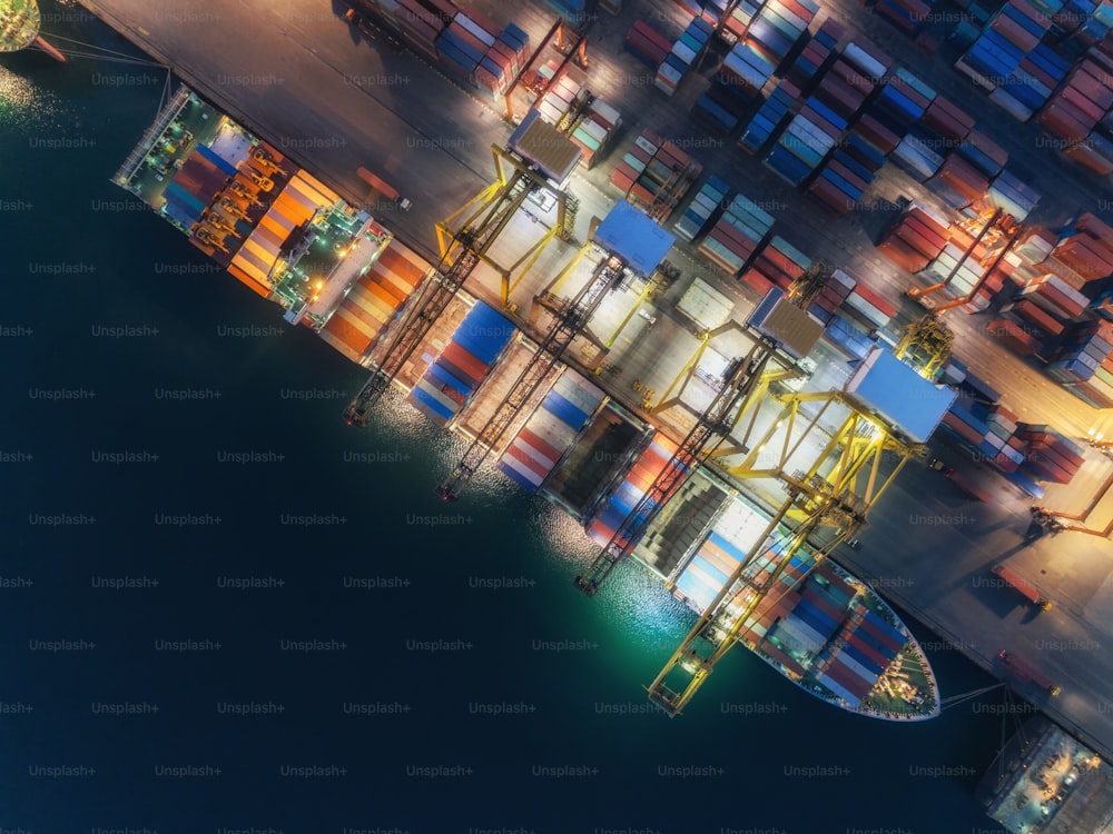 Porte-conteneurs vue aérienne au port maritime et conteneur de chargement de pont de grue de travail pour l’arrière-plan de concept d’importation ou de transport logistique.