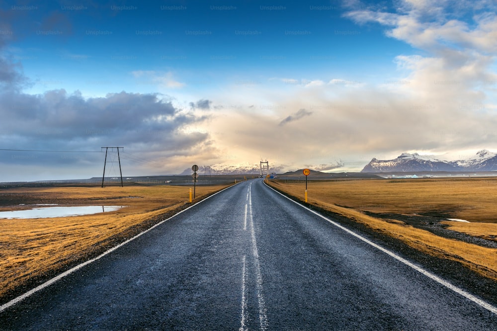 Un largo camino recto y un cielo azul, Islandia.
