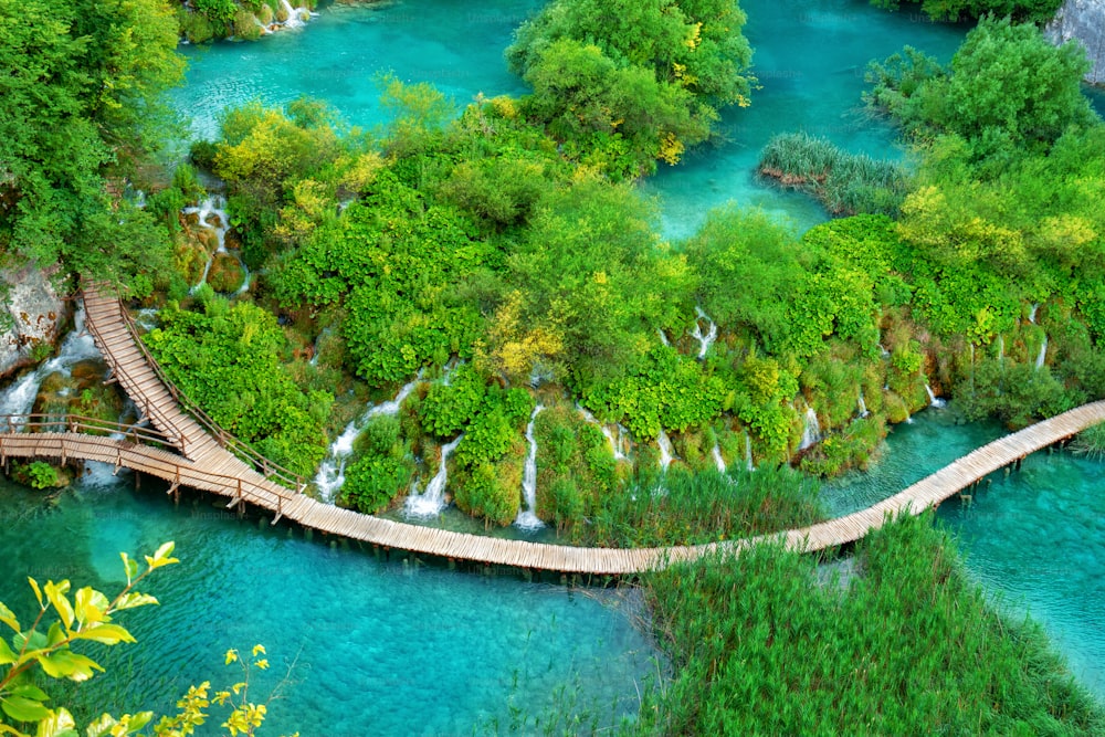 Hermoso sendero de madera para caminatas por la naturaleza con lagos y paisajes de cascadas en el Parque Nacional de los Lagos de Plitvice, patrimonio natural de la humanidad de la UNESCO y famoso destino turístico de Croacia.