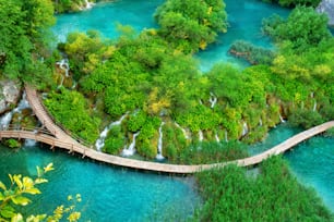 Beautiful wooden path trail for nature trekking with lakes and waterfall landscape in Plitvice Lakes National Park, UNESCO natural world heritage and famous travel destination of Croatia.