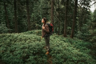 Alone with nature. Full length side view portrait of beautiful young lady with closed eyes feeling atmosphere of coniferous wood