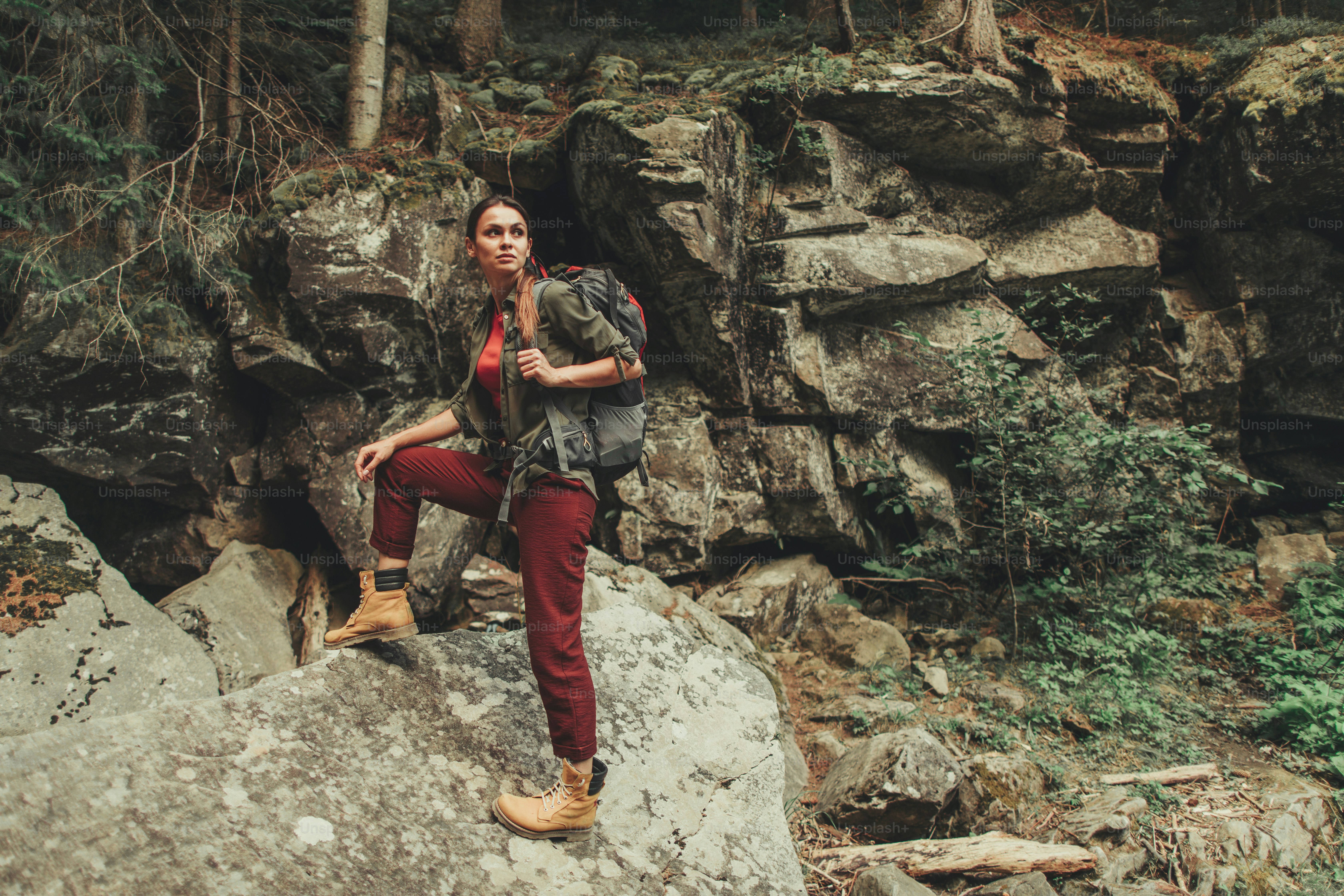 Active yougn attractive woman standing in the forest while enjoying hiking