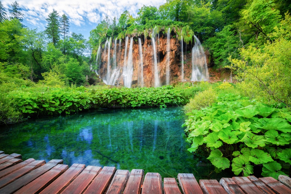Bela trilha de caminho de madeira para trekking da natureza com lagos e paisagem de cachoeira no Parque Nacional dos Lagos de Plitvice, patrimônio mundial natural da UNESCO e famoso destino de viagem da Croácia.