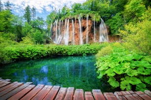 Beautiful wooden path trail for nature trekking with lakes and waterfall landscape in Plitvice Lakes National Park, UNESCO natural world heritage and famous travel destination of Croatia.