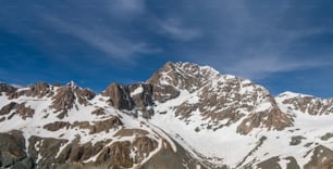 Winterlandschaft mit Schneegebirge und blauem Himmel. Landschaftskulisse für Bergaktivitäten wie Skifahren, Trekking, Wintersport und Bergsteigen.