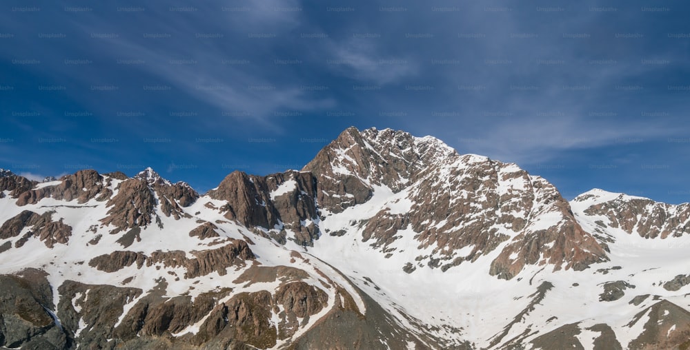Paesaggio invernale della catena montuosa innevata e del cielo blu. Sfondo paesaggistico per attività di montagna come lo sci, il trekking, gli sport invernali e l'alpinismo.