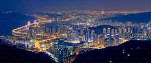 Panorama da paisagem urbana de Busan com arranha-céus e a Ponte Gwangan iluminada à noite. Busan. Coreia do Sul
