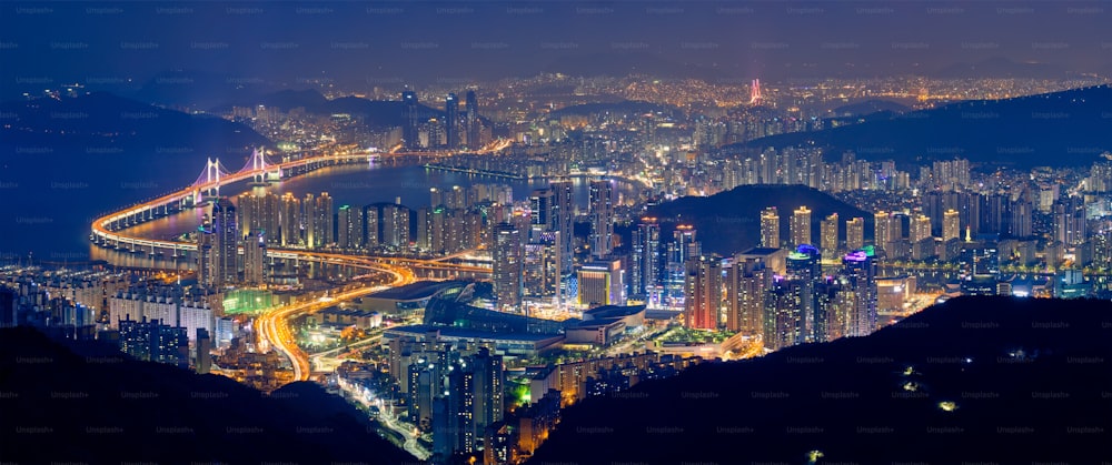 夜にライトアップされた高層ビルと広安大橋のある釜山の街並みのパノラマ。釜山。大韓民国
