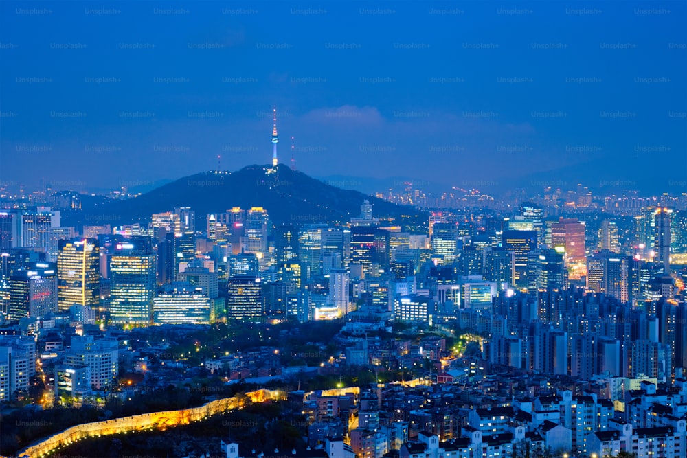 Seoul downtown cityscape illuminated with lights and Namsan Seoul Tower in the evening view from Inwang mountain. Seoul, South Korea.