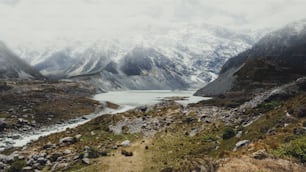 Montagne, laghi e paesaggio del prato nel paese del clima freddo con neve e tempo nuvoloso sulle montagne. Il paesaggio è stato girato a Mt Cook, in Nuova Zelanda, luogo famoso per il trekking e la vita all'aria aperta.