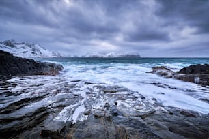 Wellen des norwegischen Meeres zerquetschen an felsiger Küste im Fjord. Vikten, Lofoten, Norwegen