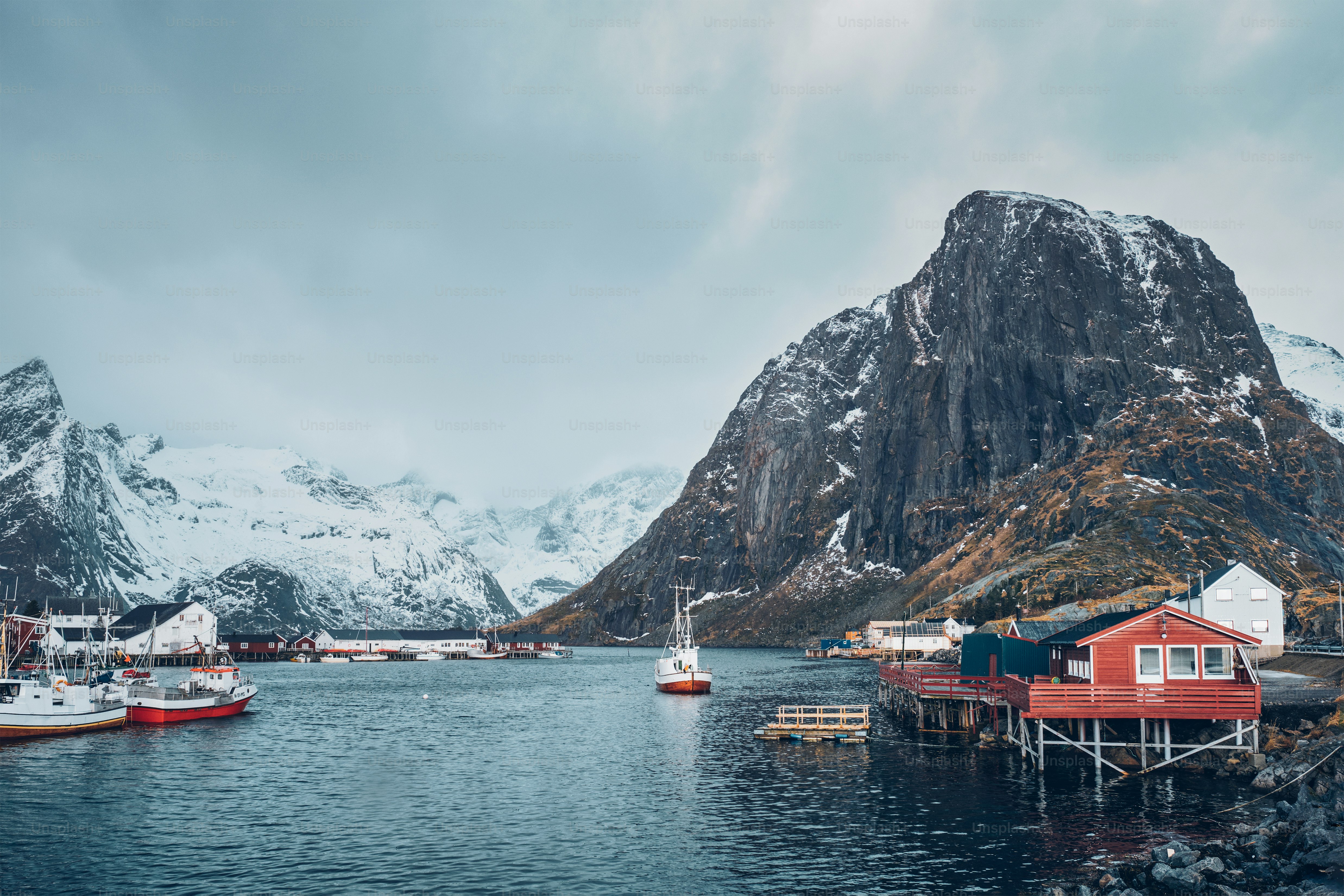Hamnoy Fischerdorf mit Schiffen Fischerboote auf den Lofoten, Norwegen mit roten Rorbu-Häusern. Bei fallendem Schnee