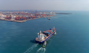 Aerial view container ship going to crane bridge for unload container to warehouse at seaport. Logistics business, import export, shipping or transportation.