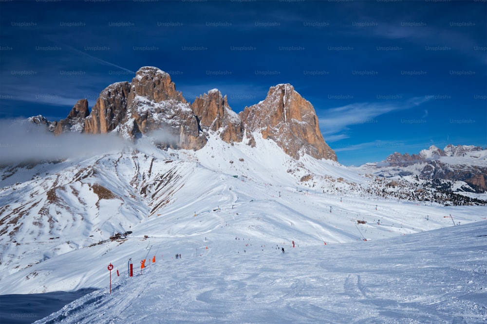 Vista di una pista di un comprensorio sciistico con persone che sciano nelle Dolomiti in Italia