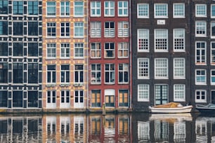 암스테르담 운하 Damrak의 전형�적인 집과 보트가 반사되어 있습니다. 암스테르담, 네덜란드