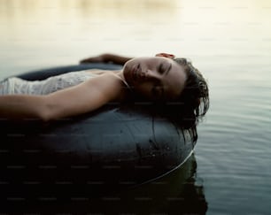 a woman laying on top of an inflatable object in the water