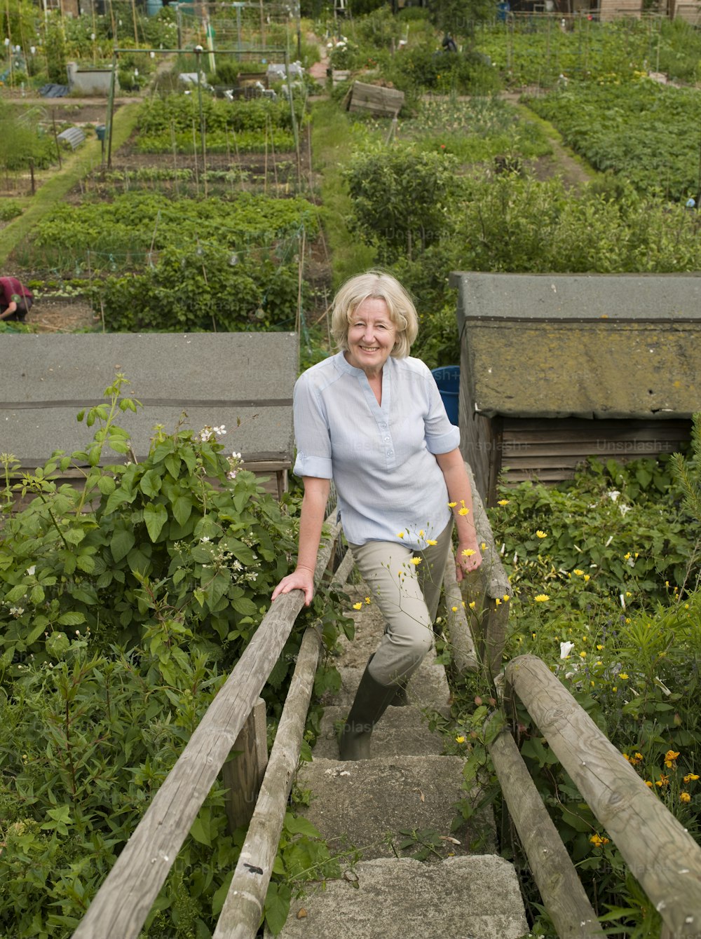 a woman standing on a set of stairs in a garden