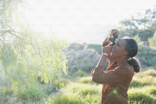 Una mujer tomando una foto de un pájaro en un campo
