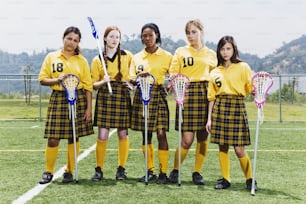 Eine Gruppe von Mädchen in Schuluniformen, die Lacrosse-Stöcke halten