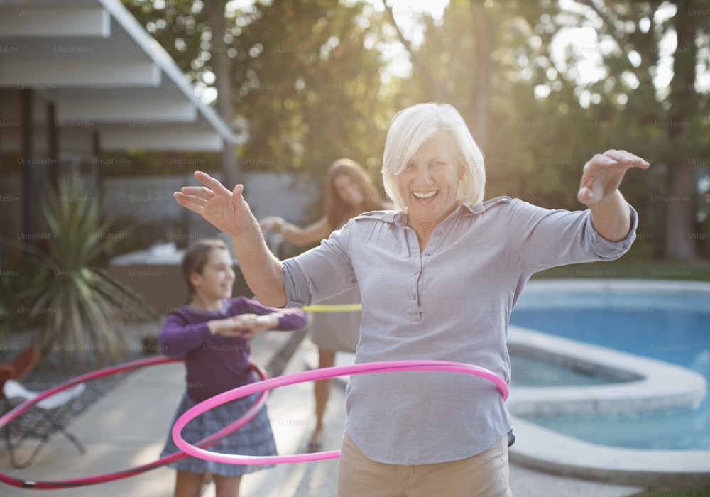 a woman holding a hula hoop near a pool