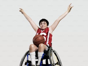 a man in a wheelchair holding a basketball