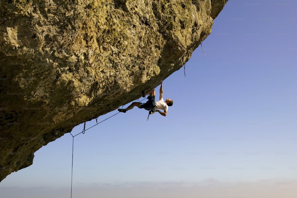 a man climbing up the side of a cliff