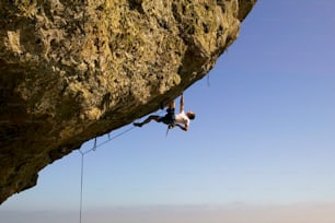 a man climbing up the side of a cliff