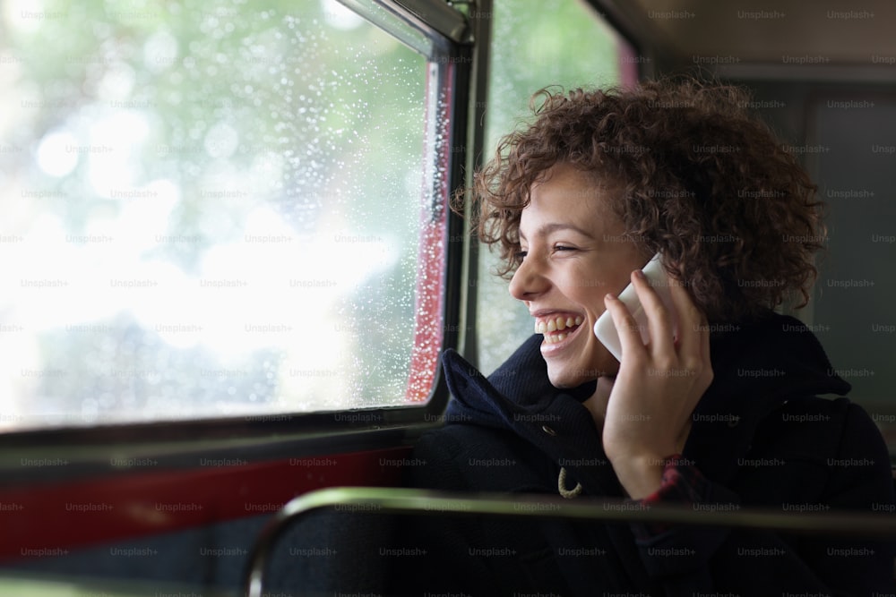 Eine Frau, die während der Busfahrt mit einem Handy telefoniert