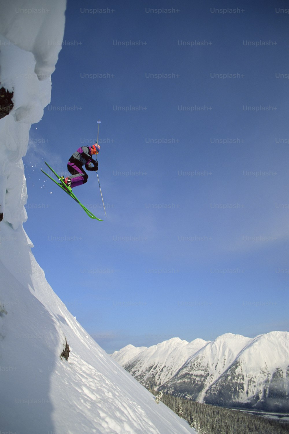 스키 한 켤레를 타고 공중으로 ��점프하는 사람