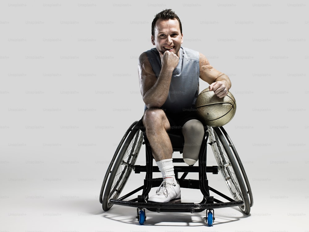 Un uomo su una sedia a rotelle con un pallone da basket in mano