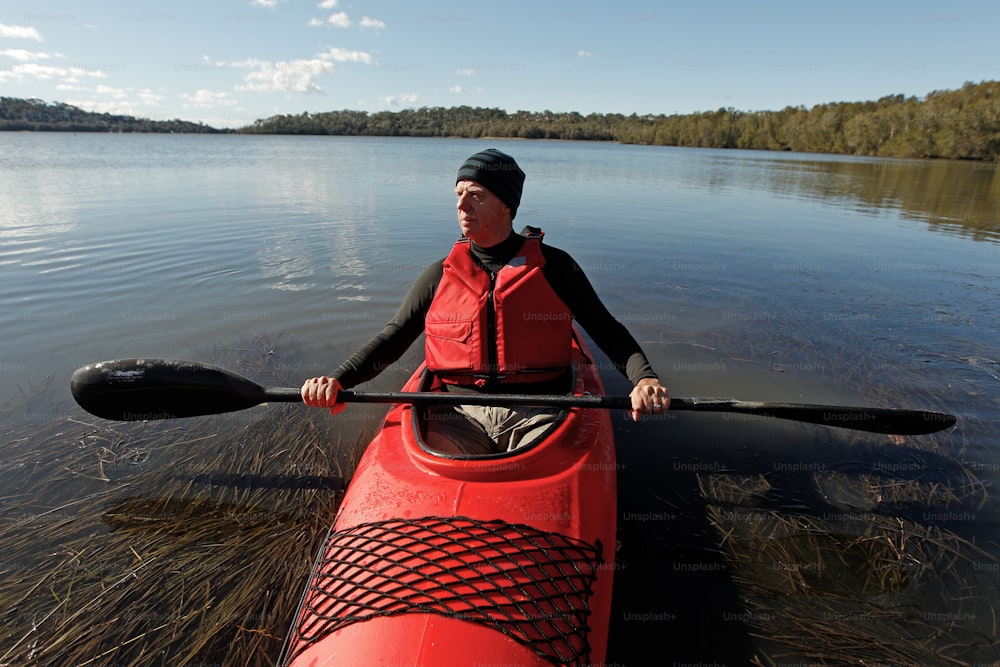 a man in a red kayak on a lake