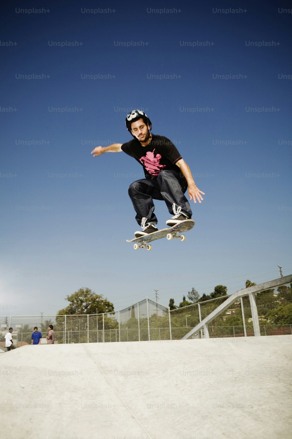 Un hombre volando por el aire mientras monta una patineta