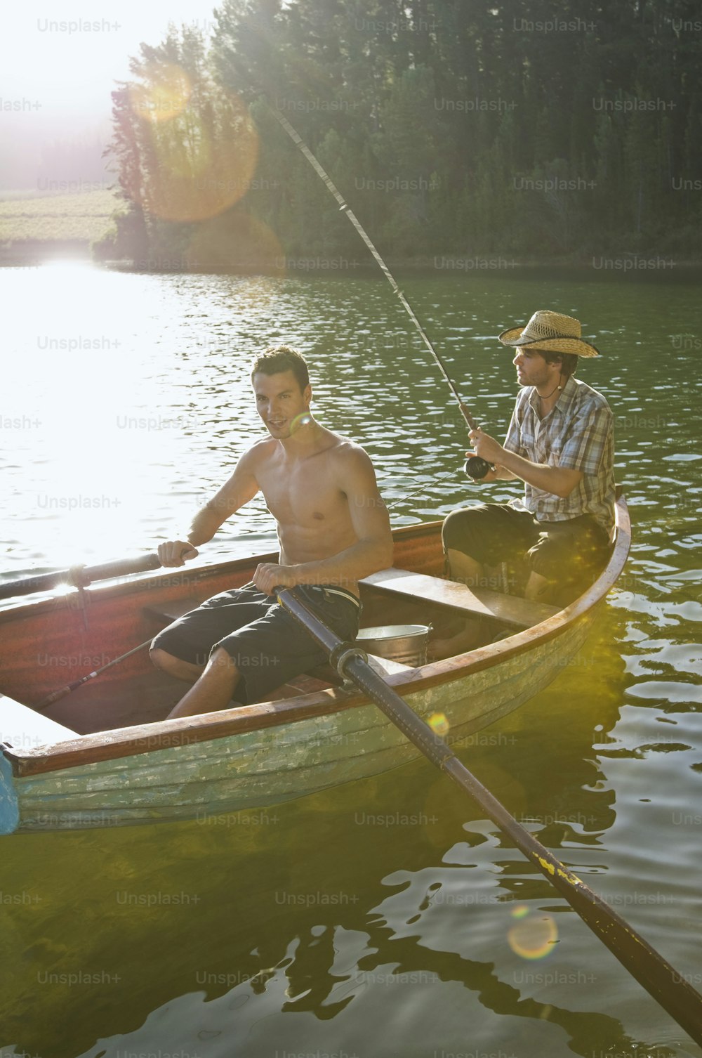 Dos hombres en un bote de remos pescando en un lago
