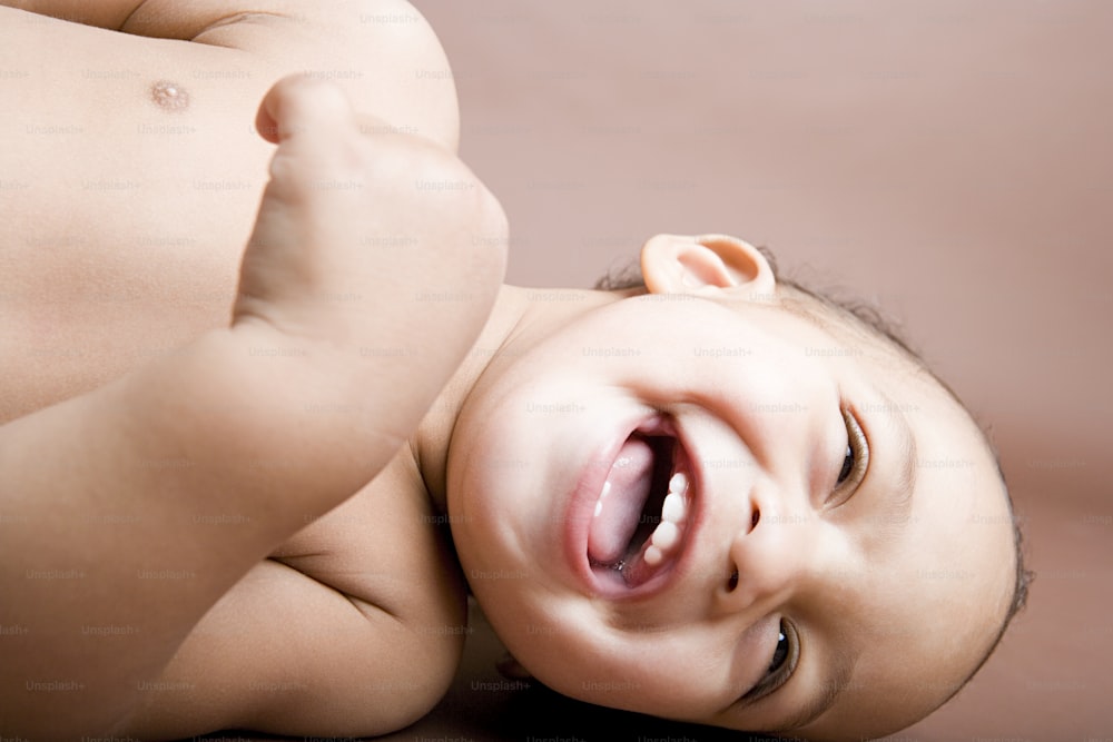 a close up of a baby laughing with its mouth open