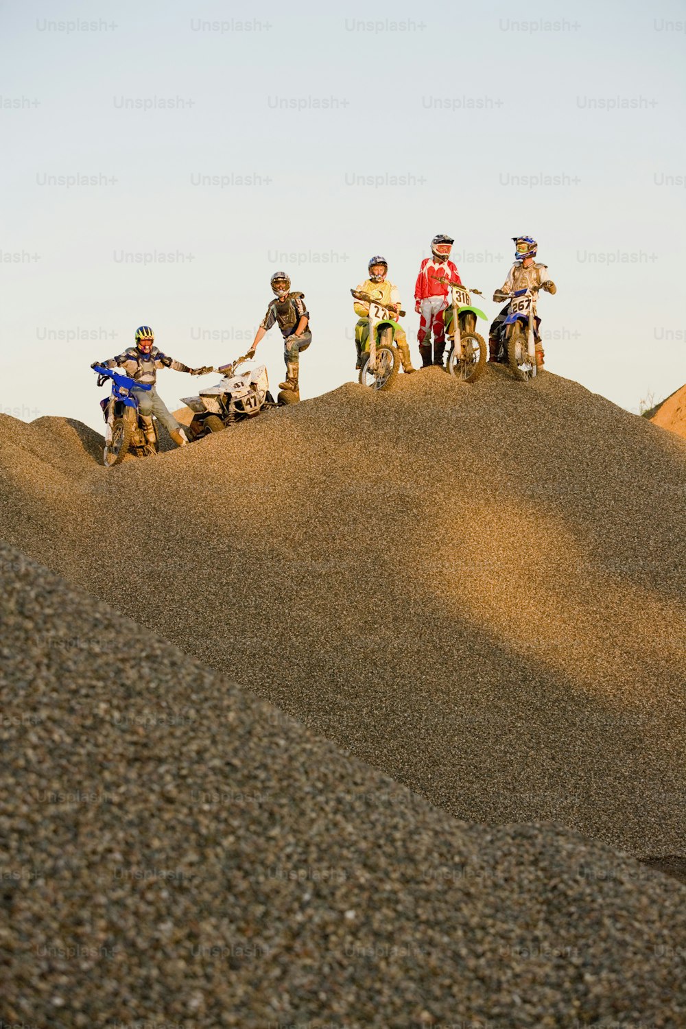 언덕 꼭대기에서 흙 자전거를 타는 한 무리의 사람들