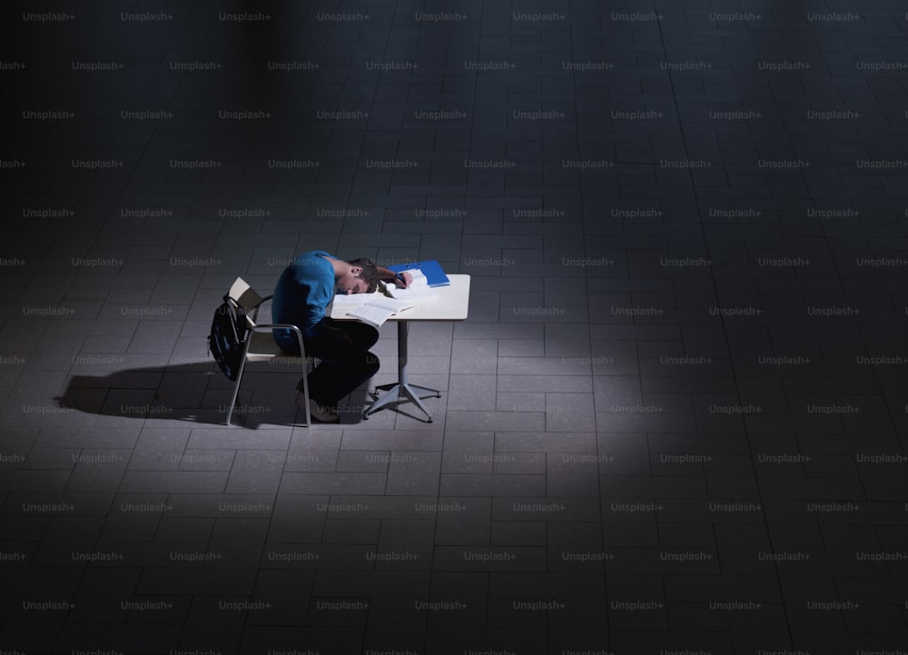 Un hombre sentado en un escritorio en la oscuridad