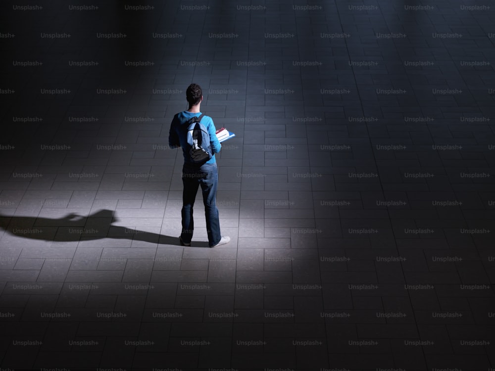 a man standing in the dark holding a book