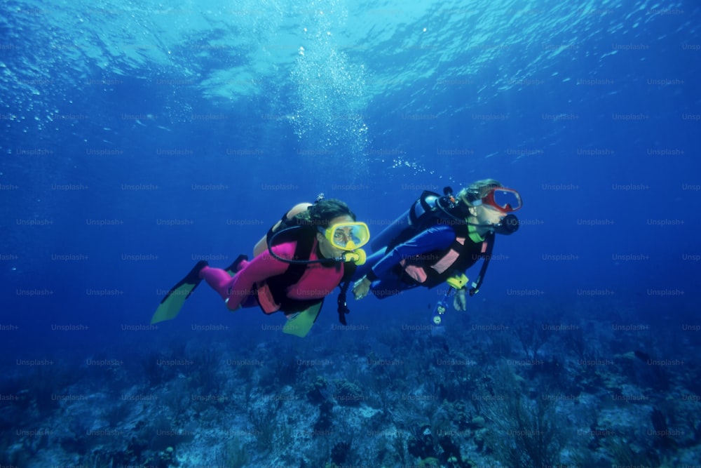 Due persone in attrezzatura subacquea che nuotano nell'oceano