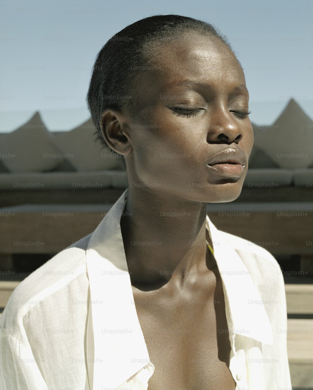 a woman with her eyes closed wearing a white shirt