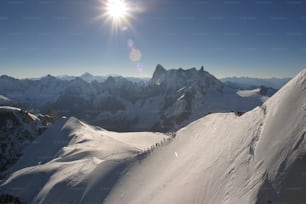 El sol brilla intensamente sobre una montaña nevada