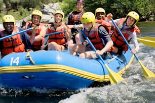 Un grupo de personas montadas en la parte trasera de una balsa río abajo