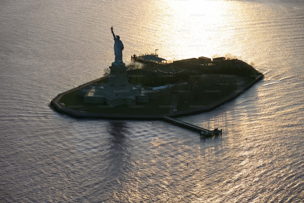 Una pequeña isla con una estatua de la libertad en la parte superior
