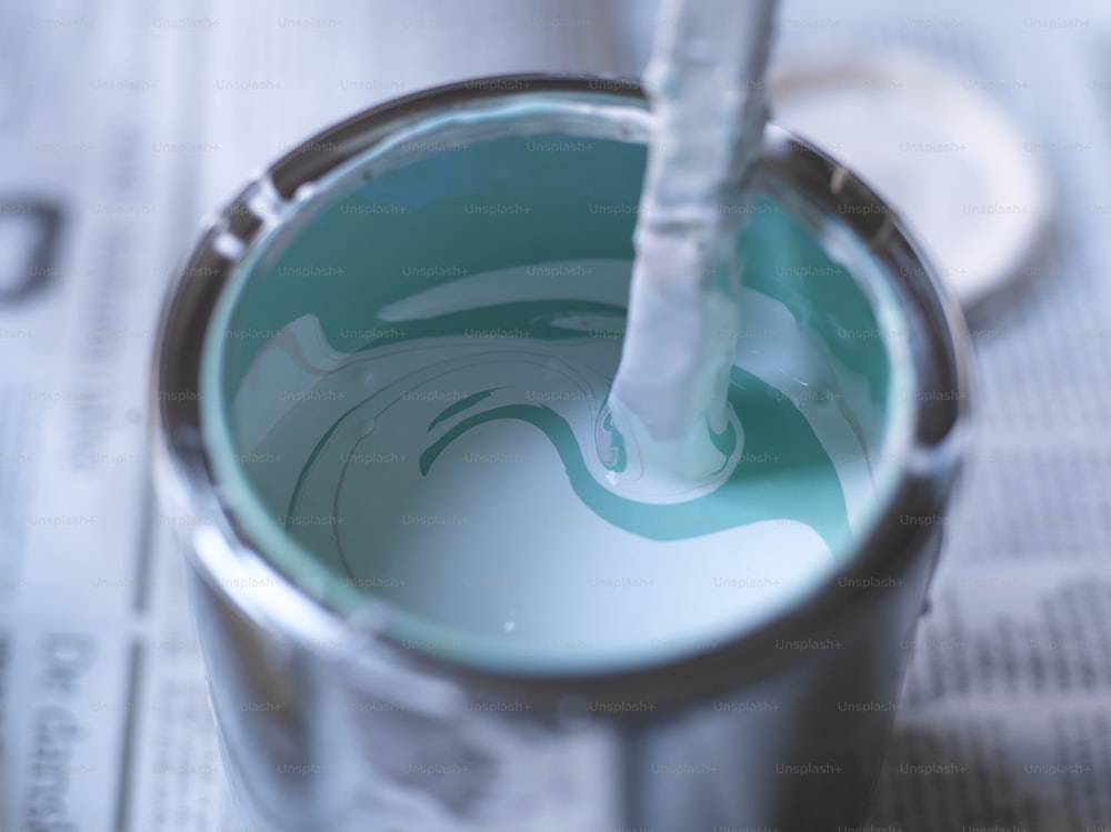 a close up of a paint can with a toothbrush in it