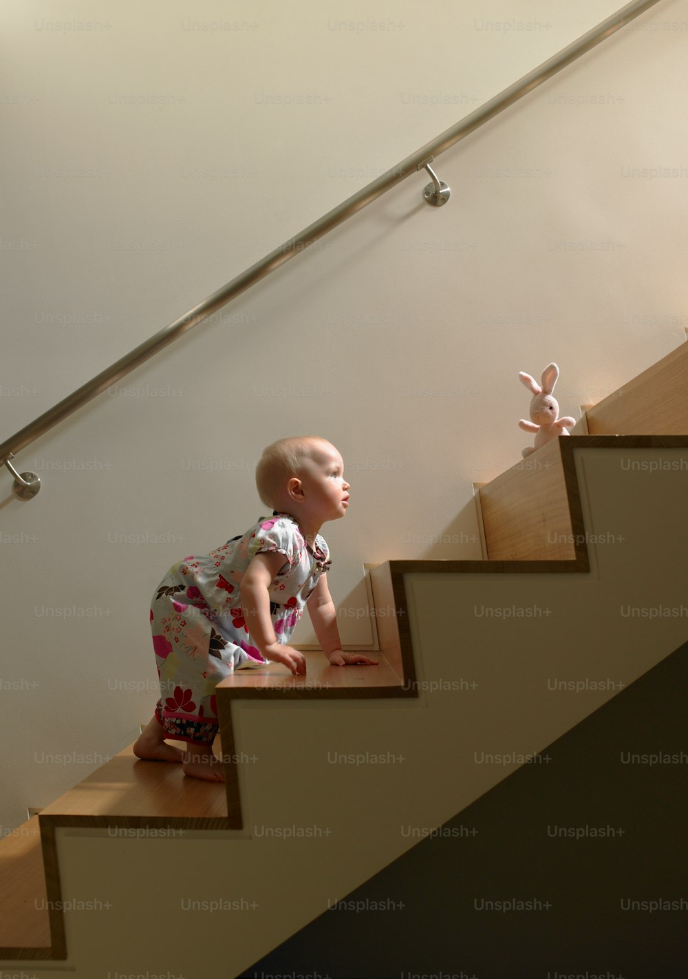 Baby girl climbing stairs to get toy