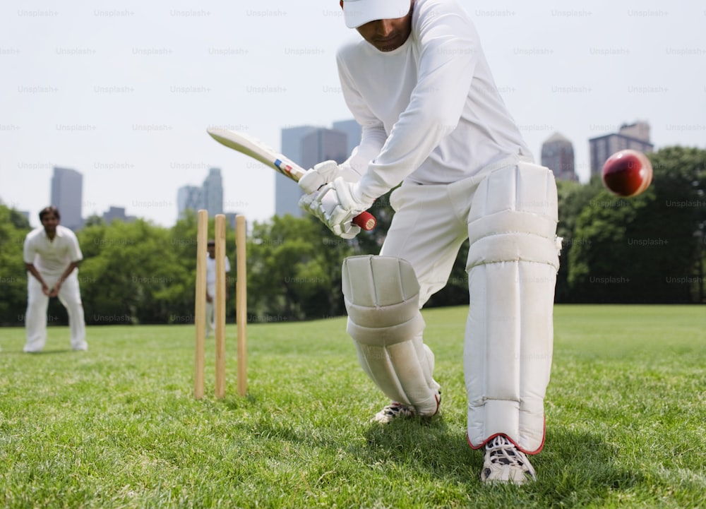 Un hombre con uniforme blanco jugando un partido de cricket